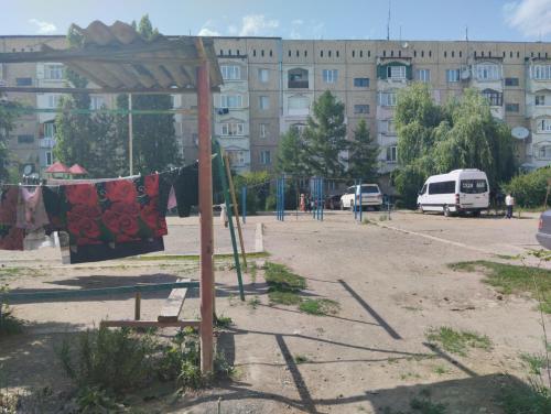 a parking lot with a clothes line in front of a building at Karakol apartment in Karakol