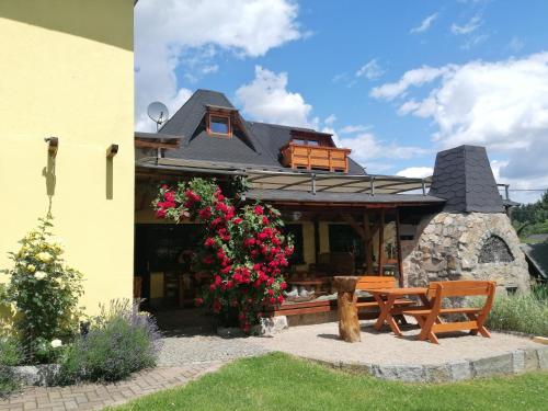 una casa con un banco y flores delante de ella en Landgasthof Plohnbachtal UG en Abhorn