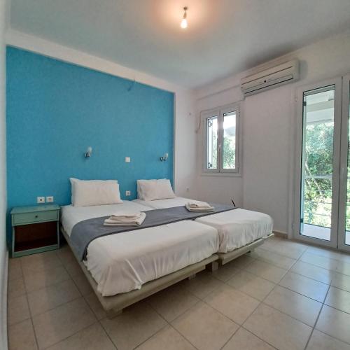 a bedroom with a large bed with a blue wall at Penthouse Vasiliki in Vasiliki
