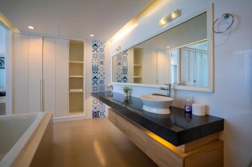 La salle de bains est pourvue d'un lavabo et d'un grand miroir. dans l'établissement Ocean View Studio,Ocean View 3BR-apartment, Sealinks City, Mui Ne, à Phan Thiết