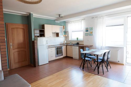 a kitchen and dining room with a table and chairs at APARTAMENTY BIAŁA MEWA in Ustka