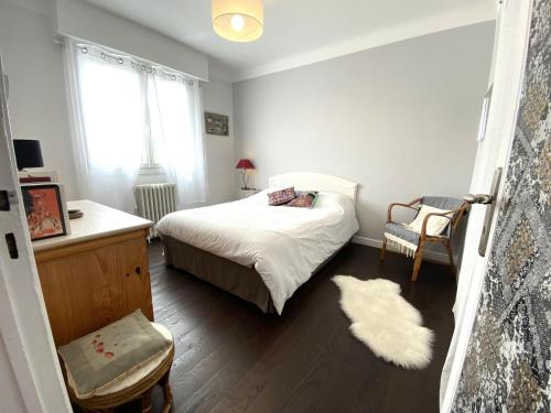 a bedroom with a bed and a desk and a chair at La barthe in Biarritz