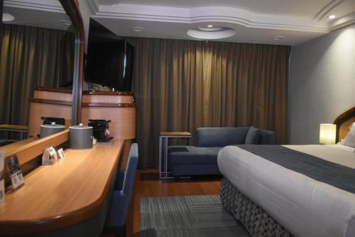 a hotel room with a bed and a chair at KALI Escandón Mexico City in Mexico City