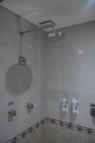 a bathroom with a shower with a light on the wall at KALI Escandón Mexico City in Mexico City
