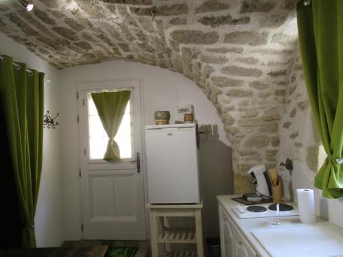 a kitchen with a white refrigerator and a window at Location studio meublé 19m² proche de la mer in Aubais