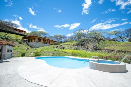 a swimming pool in a yard with a house at Vilcabamba casa / granja Vilcabamba house / farm in Loja