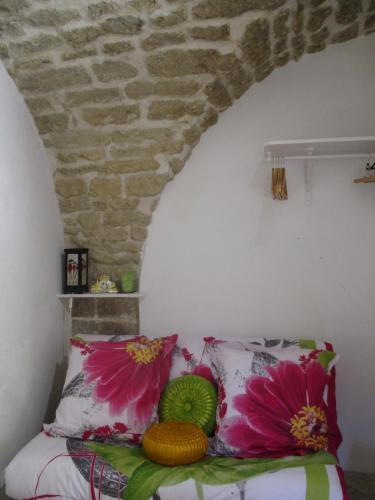 Schlafzimmer mit einem Bett mit rosa und grünen Kissen in der Unterkunft Location studio meublé 19m² proche de la mer in Aubais