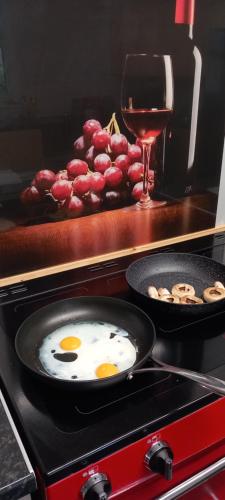 a frying pan with two eggs and a glass of wine at Ty Castell Guest House in Caerphilly