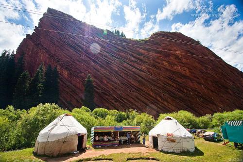 un grupo de tiendas de campaña frente a una montaña en Royal Ak-Terek Issyk-kul en Ak-Terek