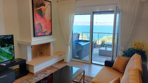 a living room with a couch and a view of the ocean at PORTO D'ORO LUXURY APARTMENT in Lávrion