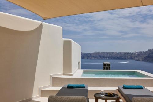 a house with a swimming pool with a view of the water at Apanemo Hotel & Suites in Akrotiri
