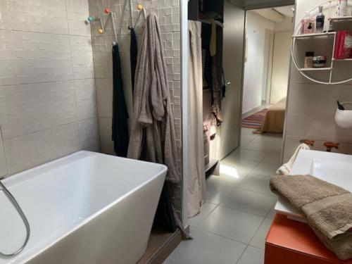 ein weißes Badezimmer mit einer Badewanne und einem Waschbecken in der Unterkunft Loft au cœur de Nîmes in Nîmes