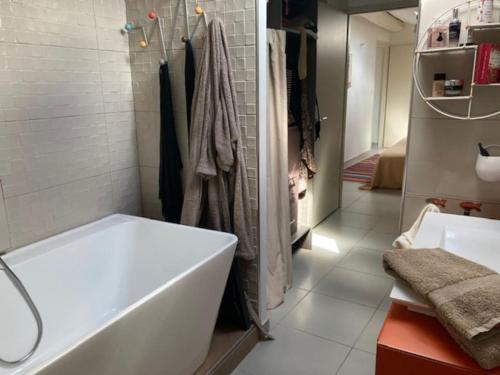 une salle de bain blanche avec une baignoire et un lavabo dans l'établissement Loft au cœur de Nîmes, à Nîmes