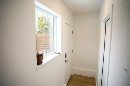 a white hallway with a window and a window sill at Life Elevated Loft: Bright, Prime Location + SAUNA in Salt Lake City