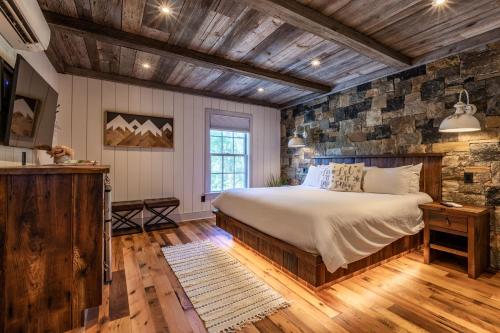 a bedroom with a bed and a stone wall at The Barnstead Inn in Manchester Center