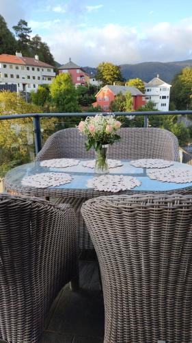 a table with chairs and a vase of flowers on it at Bergen Bliss: Mountain View in Bergen