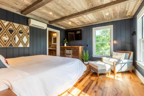 a bedroom with a large bed and a wooden ceiling at The Barnstead Inn in Manchester Center