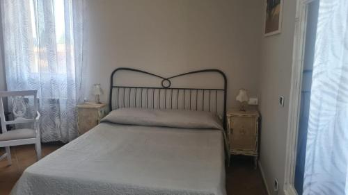 a bed in a bedroom with two tables and a chair at La Torre in Castiglion Fiorentino