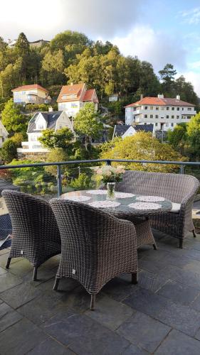 a table and chairs on a patio with a view of a city at Bergen Bliss: Mountain View in Bergen