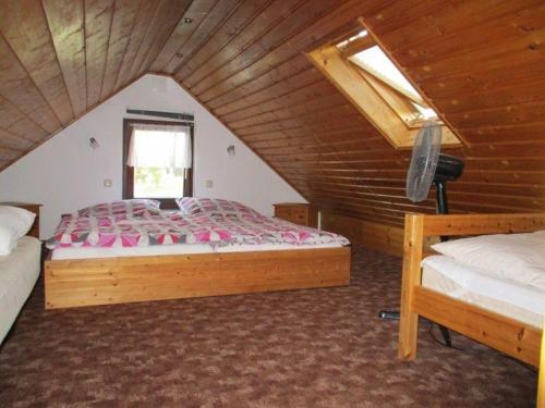 1 Schlafzimmer mit 2 Betten in einem hölzernen Dachgeschoss in der Unterkunft Ferienhaus der Familie Demmler in Crottendorf