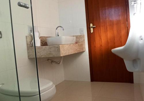 une salle de bain avec un lavabo et des toilettes dans l'établissement Chácara Santa Luzia, à Socorro