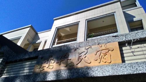 a building with graffiti on the side of it at 甘丹民宿-三義車站前客家幣合作店家 in Sanyi