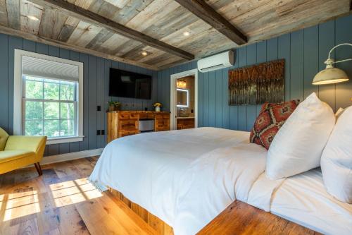 ein Schlafzimmer mit blauen Wänden und einem großen Bett in der Unterkunft The Barnstead Inn in Manchester Center