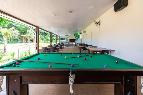 a pool table in a room with a pool at Cataratas Park Hotel e Eventos in Foz do Iguaçu