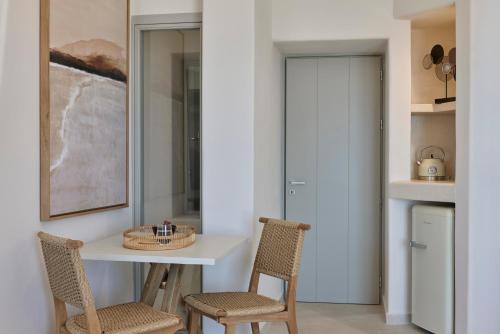 a kitchen with two chairs and a table and a counter at Apanemo Hotel & Suites in Akrotiri