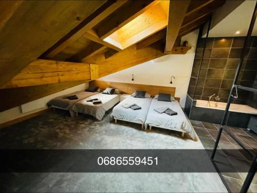 une chambre avec deux lits dans un grenier dans l'établissement Beaver Creek appartement 12 Personnes à Val Cenis, à Lanslebourg-Mont-Cenis