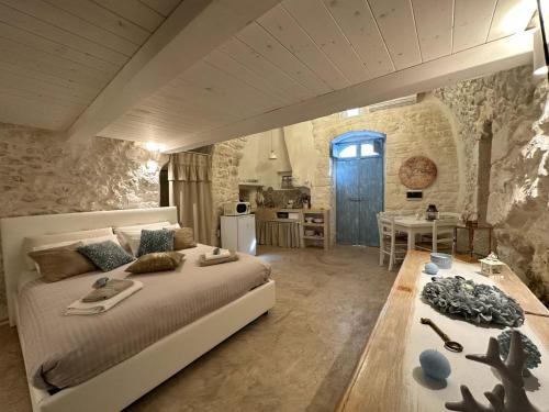 een grote slaapkamer met een groot bed en een tafel bij Bianco Calce - Ostuni in Ostuni