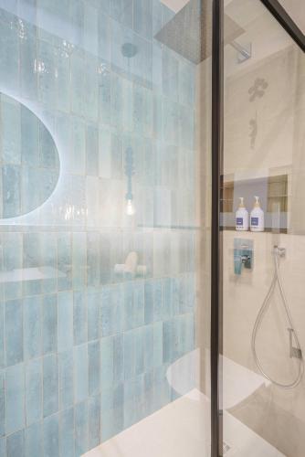 a bathroom with a shower with blue tiles at Sitges Spaces Mediterranean Penthouse in Sitges