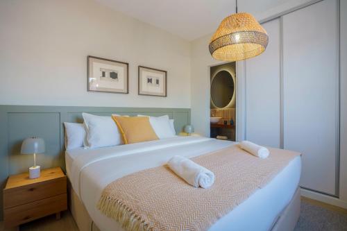 a bedroom with a large white bed and a lamp at Sitges Spaces Mediterranean Penthouse in Sitges