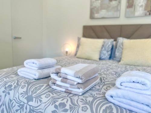 uma pilha de toalhas sentadas em cima de uma cama em Luxury 1 Bed Apt With Pool Access In Eurocity em Gibraltar