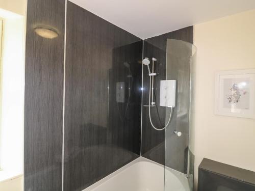 a shower with a glass door in a bathroom at Holly Leaf Cottage - Drum Castle Estate in Banchory