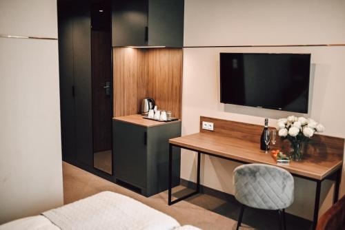 a hotel room with a desk and a television at Rytebłota Resort & Spa in Zbiczno