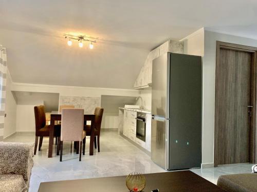 a kitchen and dining room with a table and a refrigerator at Coastal vista retreat in Neos Panteleimonas