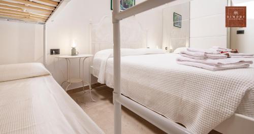 a white bedroom with a bed with white sheets at Dimore Anna Maria -Il Magazzino- in Avola
