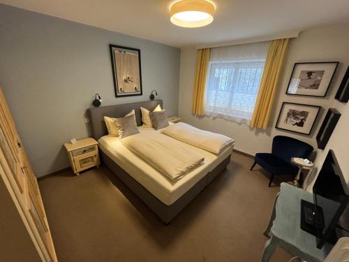 ein Schlafzimmer mit einem Bett, einem Stuhl und einem Fenster in der Unterkunft Koller, Pension Haus in Kitzbühel