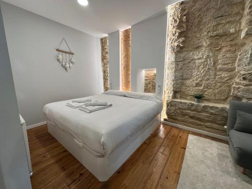 a bedroom with a bed and a stone wall at Oktheway Marina in A Coruña