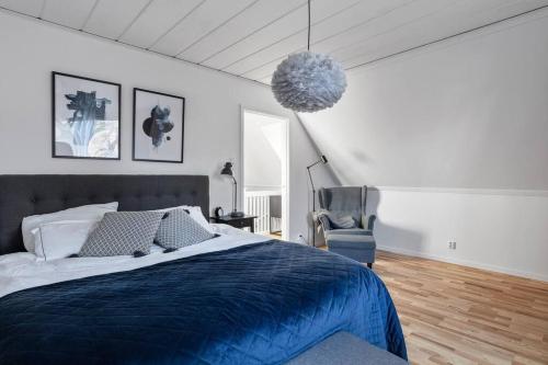 a bedroom with a blue bed and a chair at Amazing family home in Stockholm in Stockholm