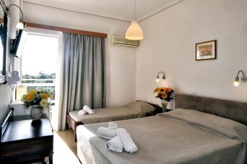 a hotel room with two beds and a window at Siagas Beach Hotel in Agioi Theodoroi