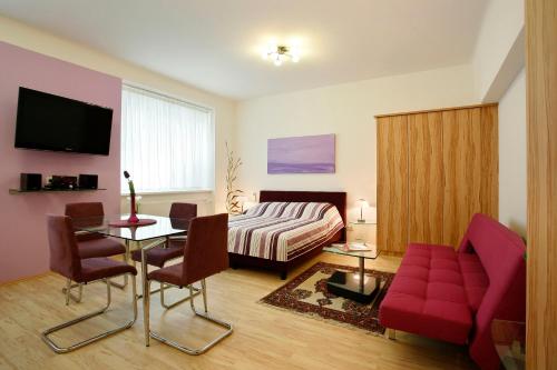 ウィーンにあるセントラル アパートメンツ ヴィエナ - CAVのベッド、テーブル、ソファが備わる客室です。