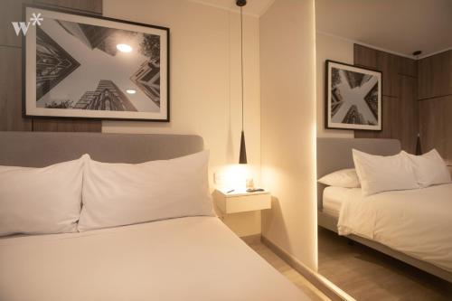 a bedroom with a bed and a night stand with a lamp at El Sol by Wynwood House in Lima