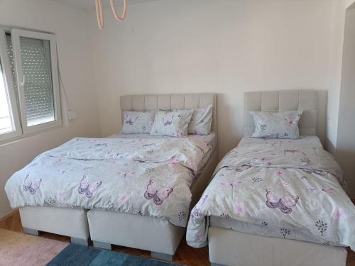 1 dormitorio con 2 camas con almohadas de mariposa en Big Apartment Veles, en Veles