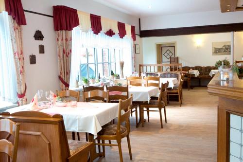 a dining room with white tables and chairs at Landhaus Sterdebüll in Bordelum