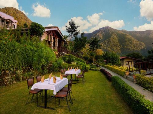 a group of tables and chairs with mountains in the background at Sterling Corbett in Marchula