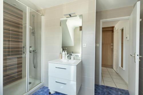 y baño con lavabo y ducha. en Le Dixmude, appartement proche plage de Morgat, en Crozon