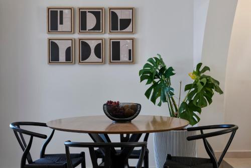 a dining room table with chairs and a plant at Apanemo Hotel & Suites in Akrotiri