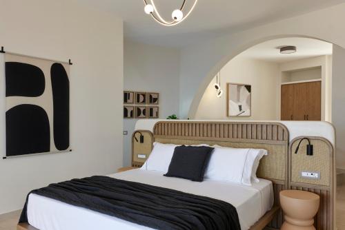 a bedroom with a large bed with a black blanket at Apanemo Hotel & Suites in Akrotiri